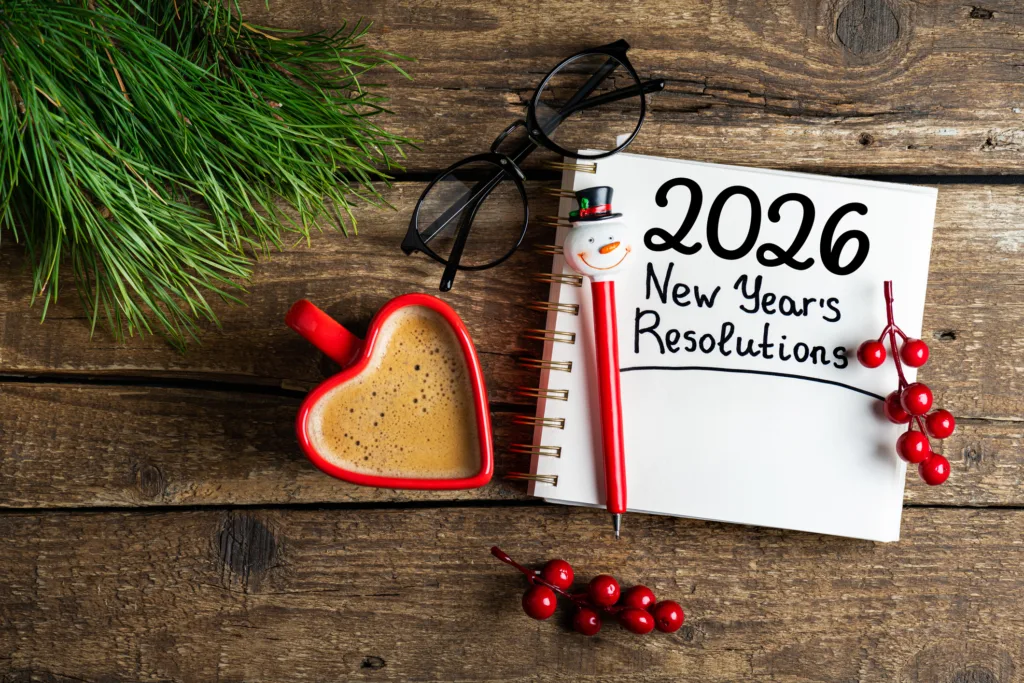 New year resolutions 2026 on desk. 2026 goals list with notebook, coffee cup on wooden table. Resolutions, plan, goals, action, checklist, idea concept. New Year 2026 resolutions