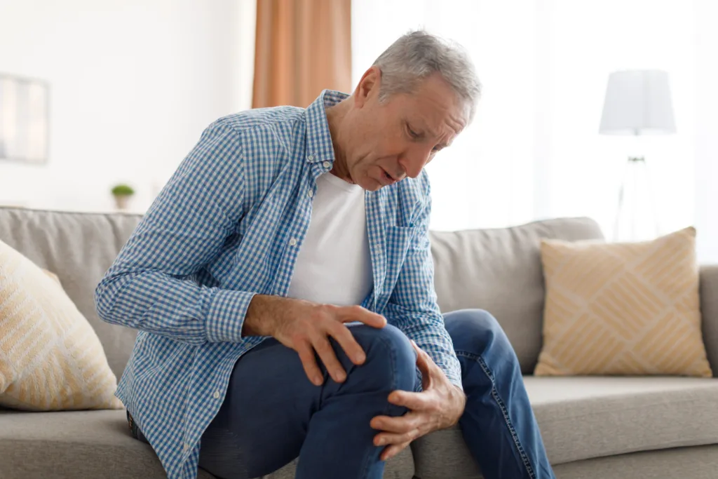 Osteoarthritis. Senior man holding touching his knee feeling acute pain,