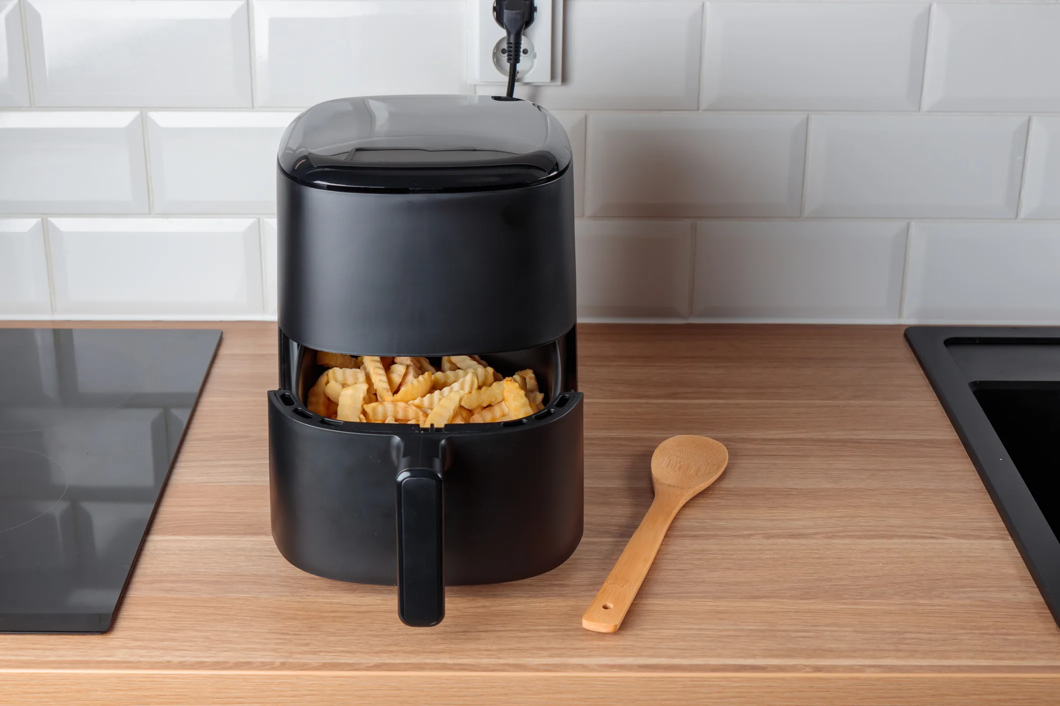 Trendy kitchen gadget air fryer machine cooking deep-fried potato. Lifestyle of new cooking, small countertop convection oven, deep fast frying oil free, more healthful way to cook deep-fried food