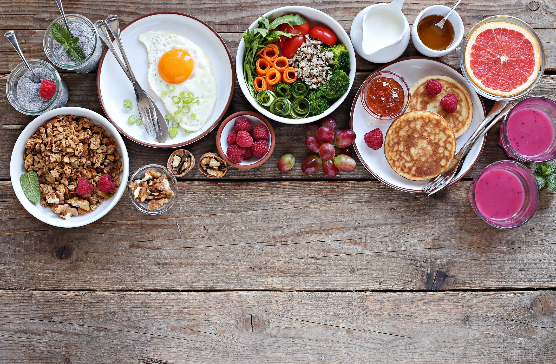 Festive brunch set, meal variety with quinoa salad bowl, fried egg, granola, pankes, chia seeds pudding and smoothy