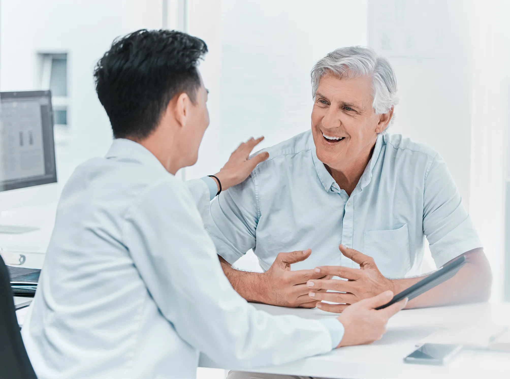 Shot of a mature man sitting with his doctor and going over his medical results on a digital tablet in the clinic