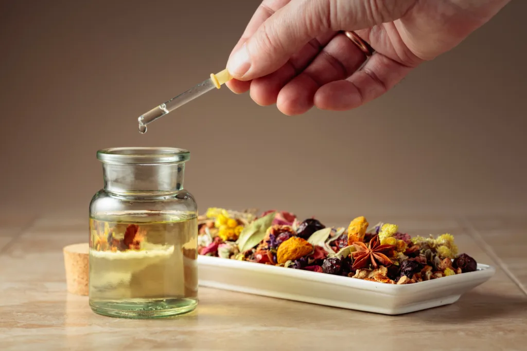 Dropping essential oil or herbal tincture into a glass bottle.