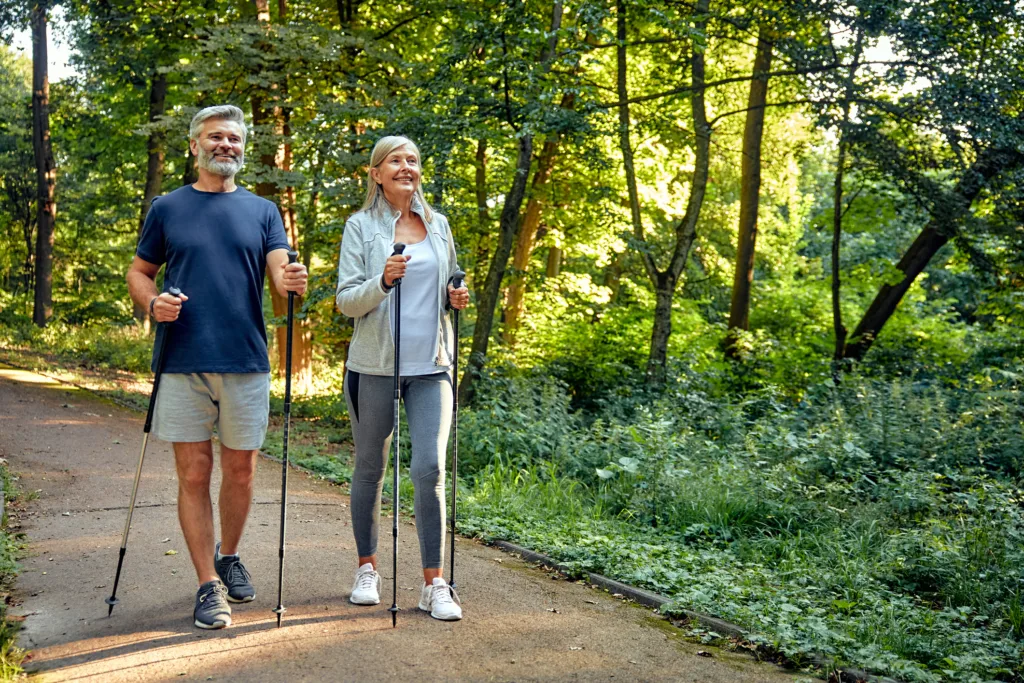 Active and Engaged Seniors Delight in a Nature Walk in the Park Using Nordic Poles