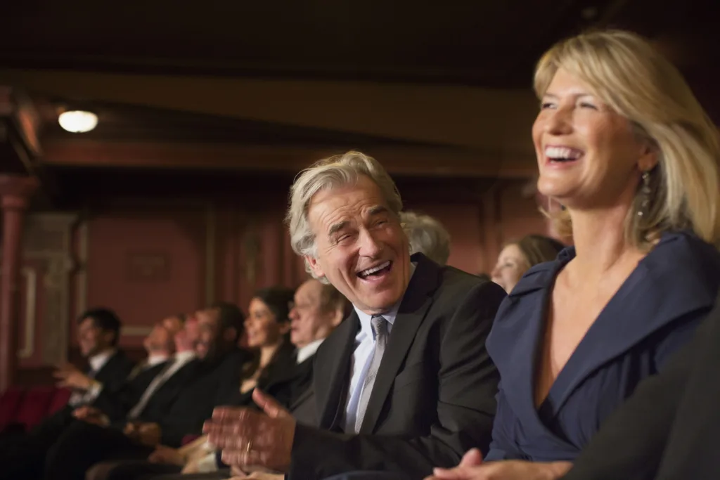 Couple laughing and clapping in theater