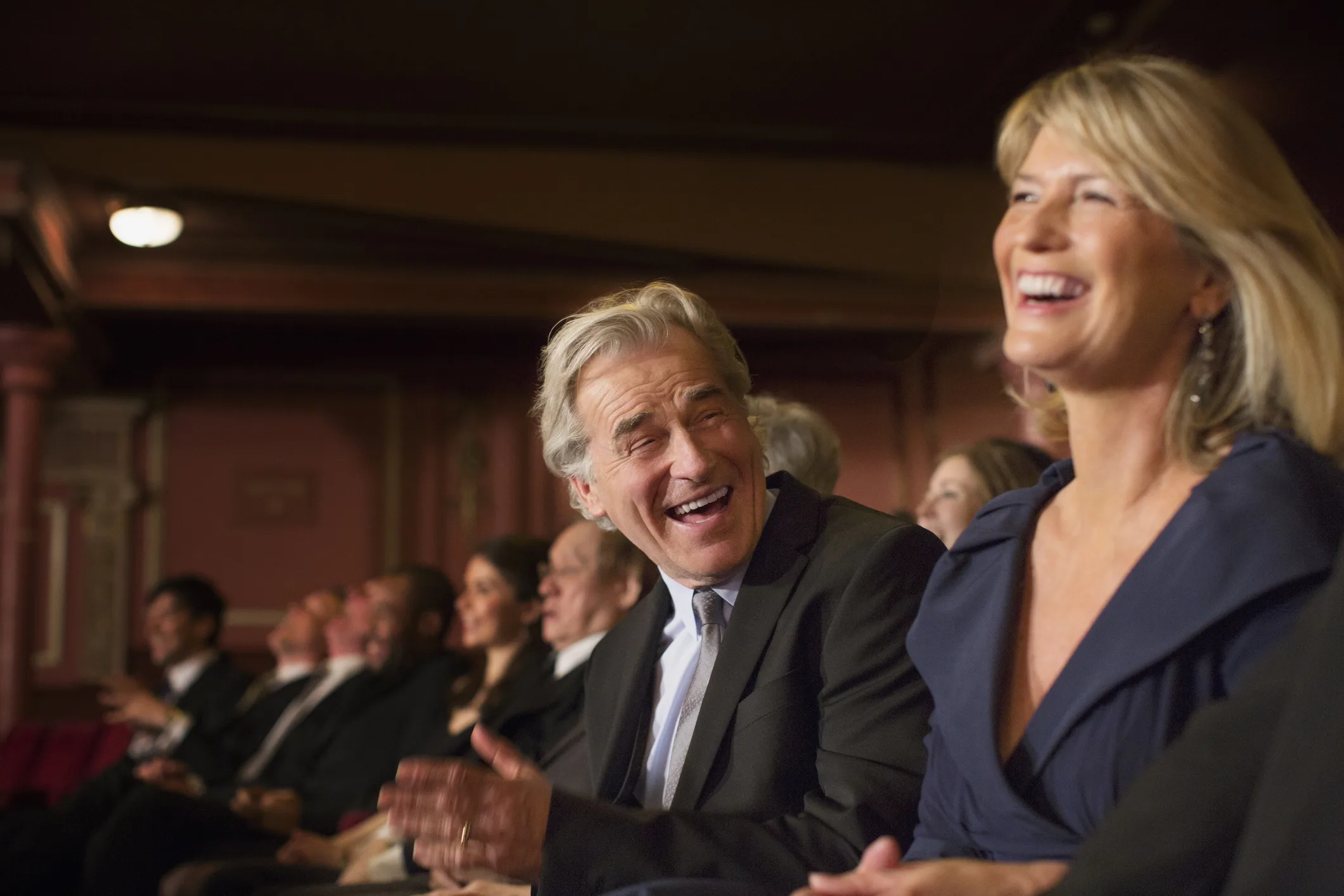 Couple laughing and clapping in theater