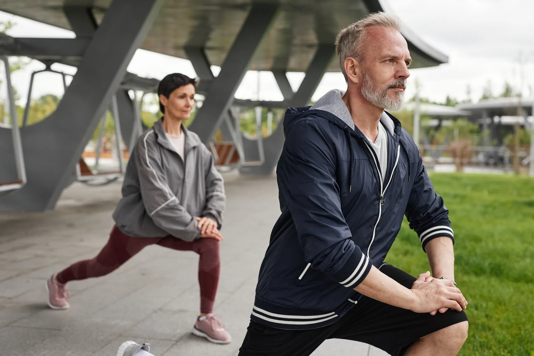 Older Couple Lunging Working out Together at City Park
