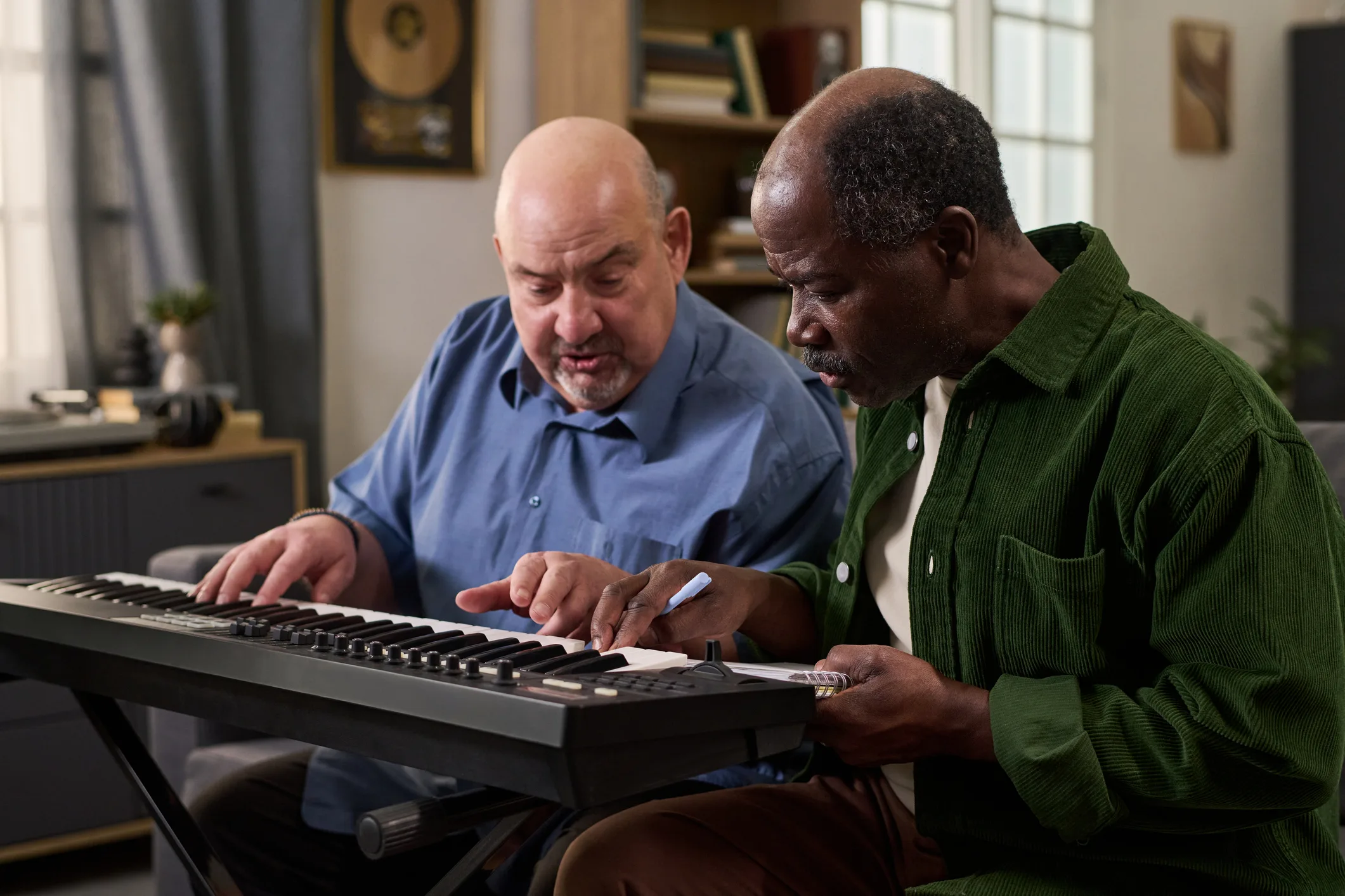 Senior Black Man Practicing Electronic Keyboard with Middle Aged Caucasian Man