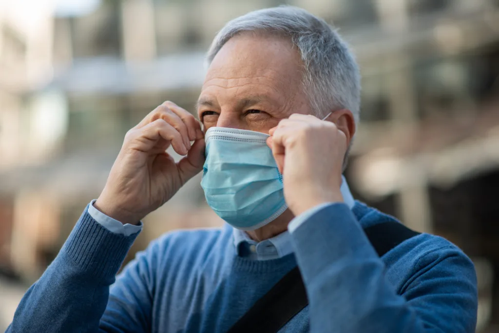 Senior man wearing protective face mask outdoors