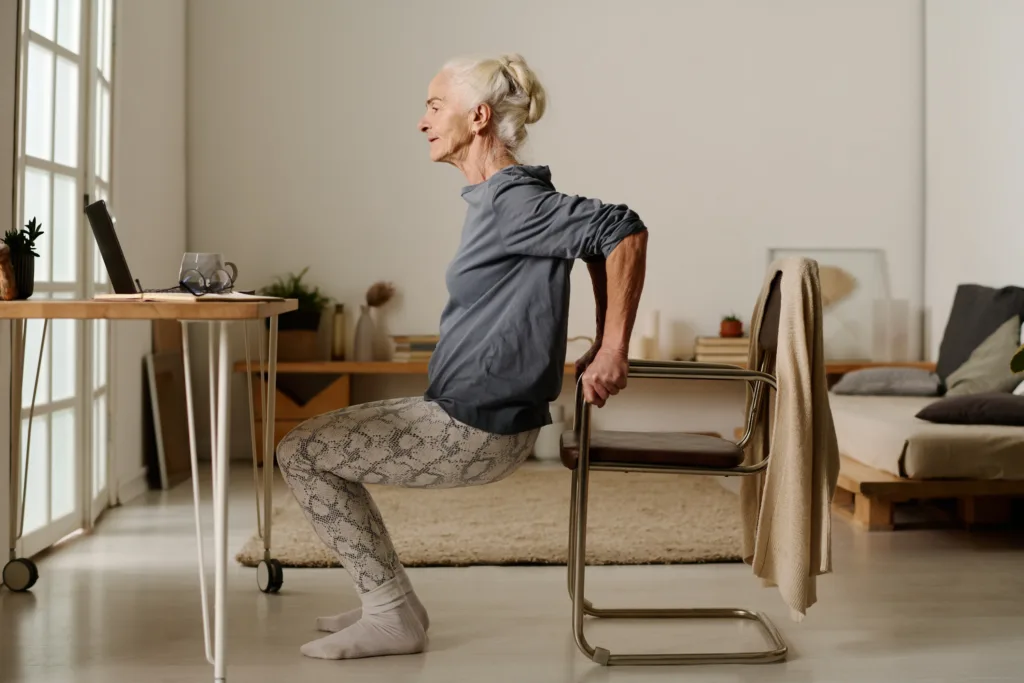 Woman doing squats in front of laptop