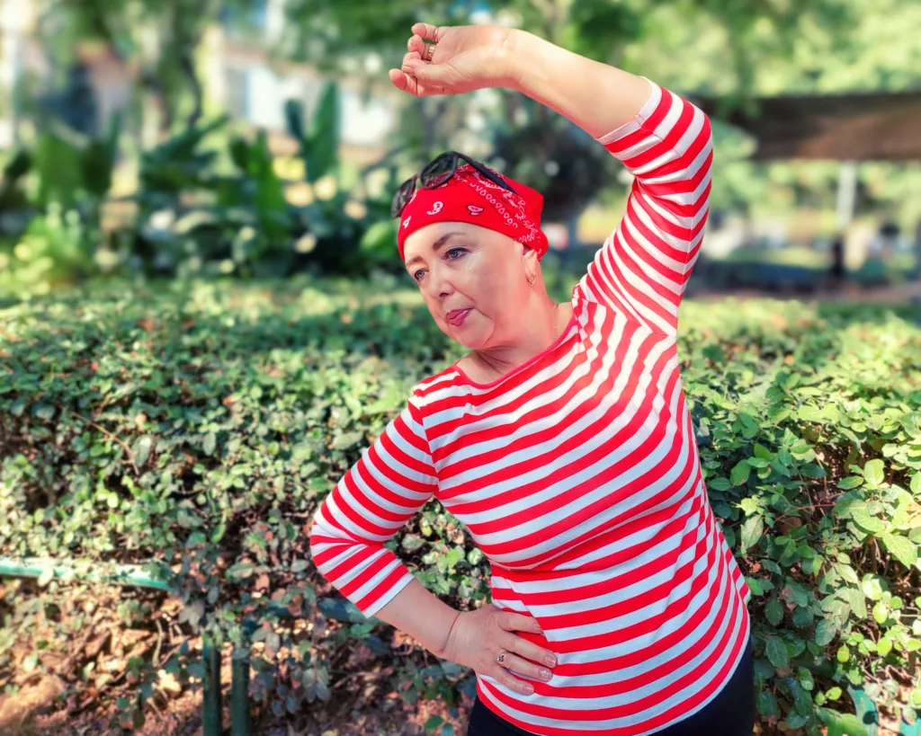 Morning Park Exercises: Woman in Red Bandana Fights Cancer with Focused and Calm Side Bends.