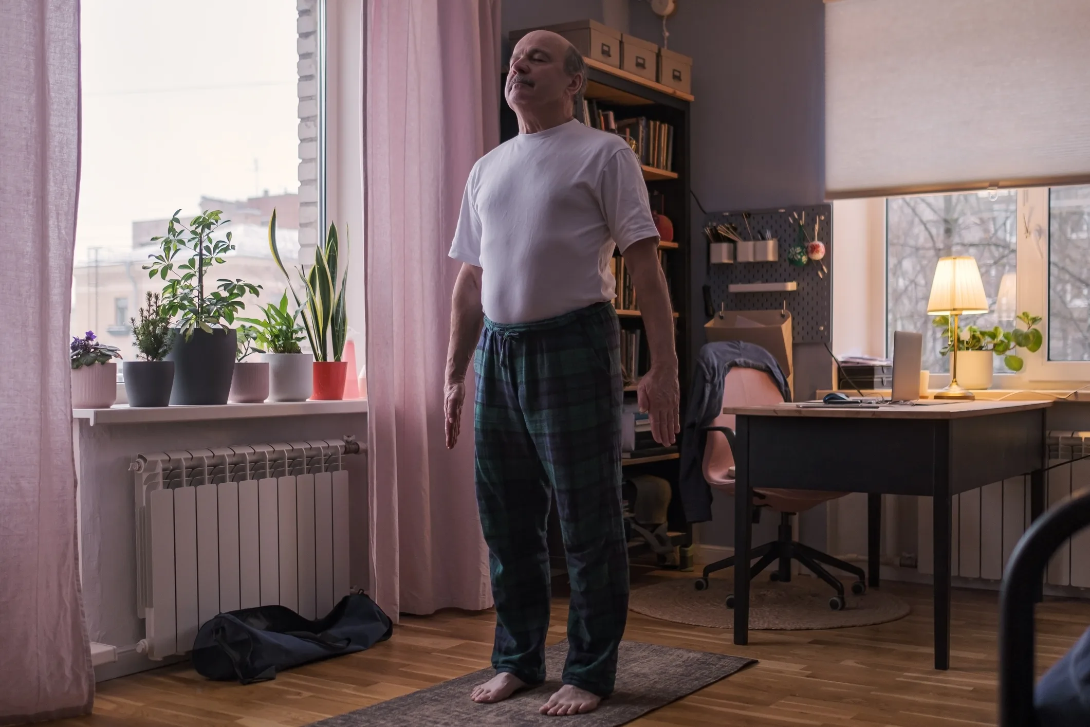 Senior man working out, yoga in basic standing asana tadasana, mountain posture