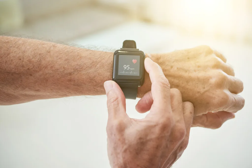 Crop senior man measuring pulse with smart watch