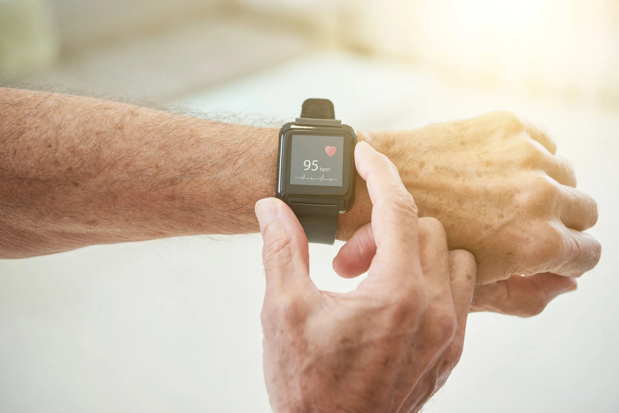 Crop senior man measuring pulse with smart watch