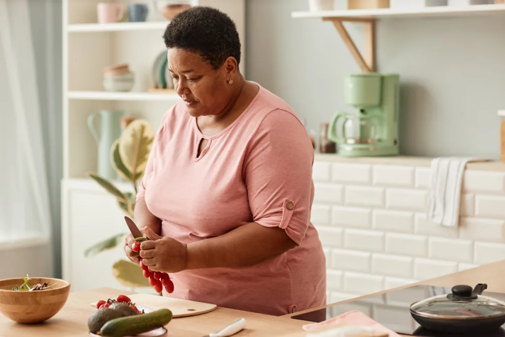 Senior black woman cooking healthy salad