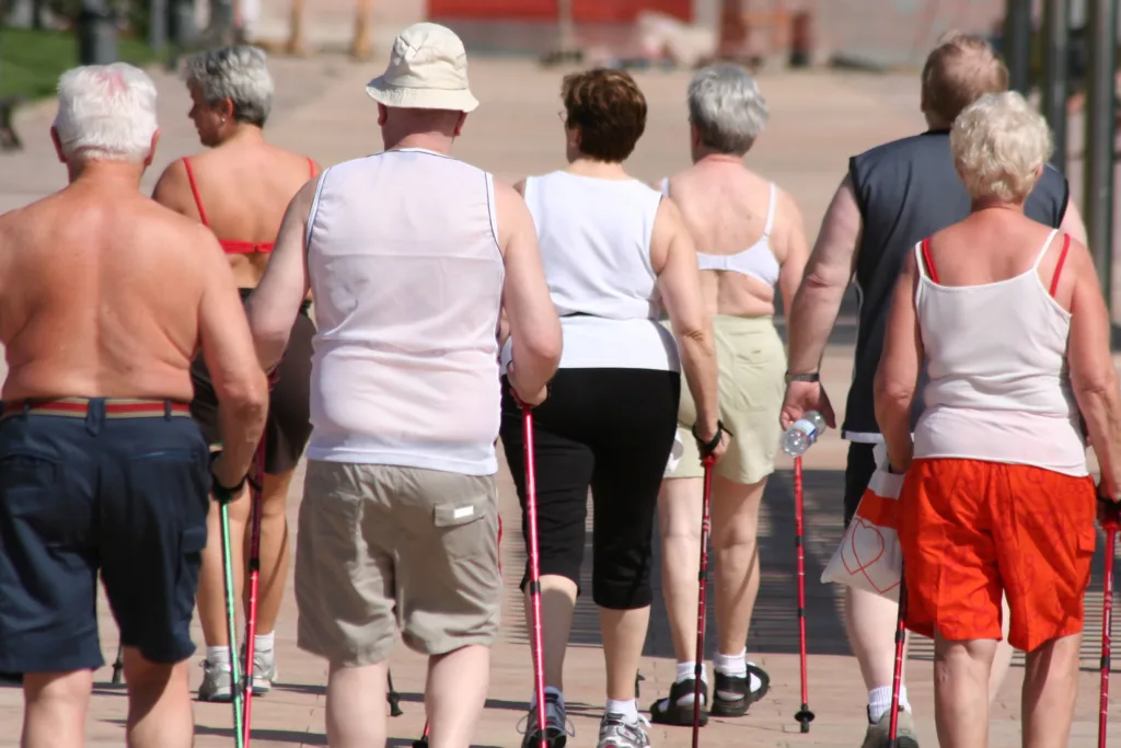 Seniors exercising walking outdoors with backs to camera