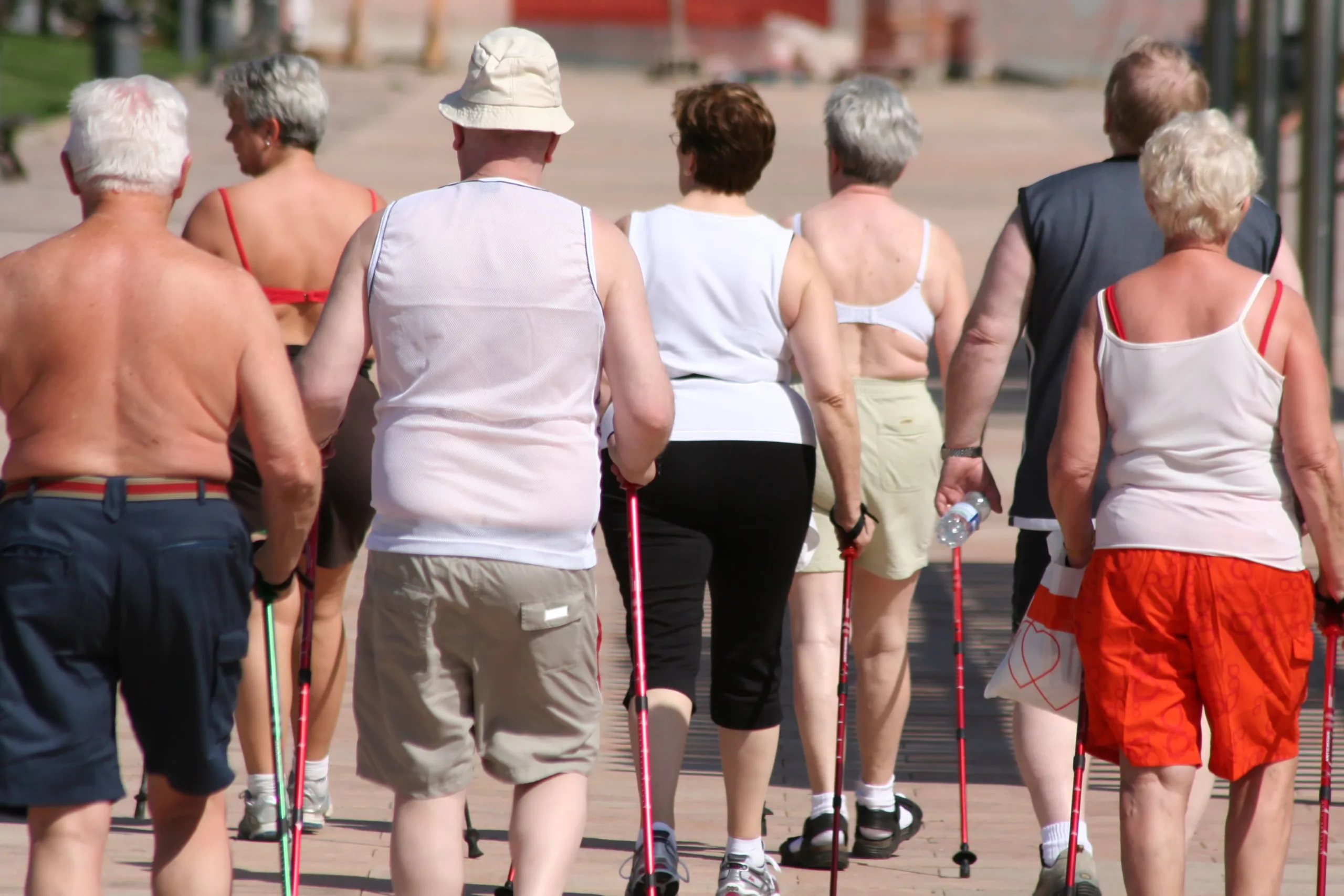 Seniors exercising walking outdoors with backs to camera
