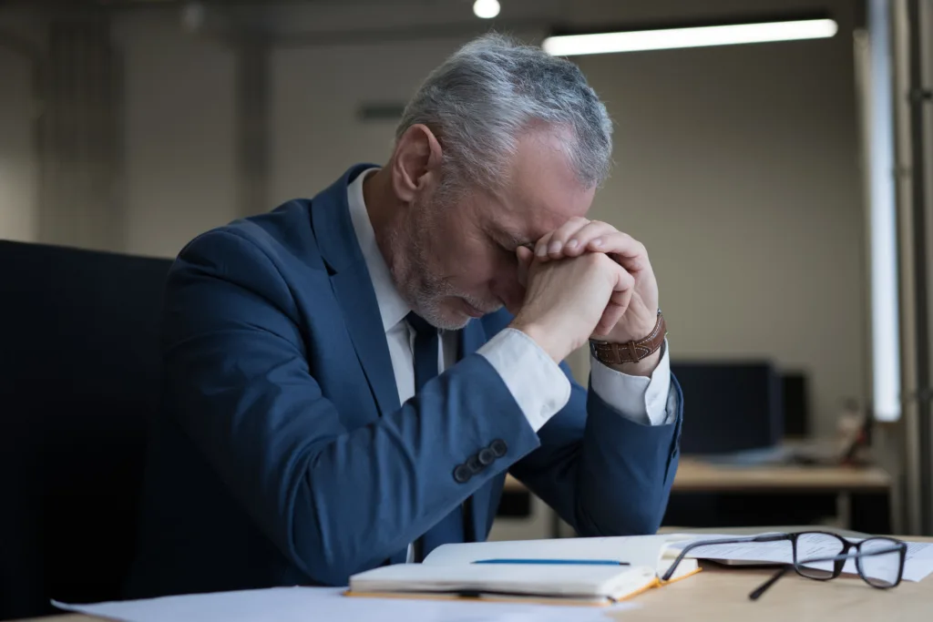 Tired stressed businessman sitting in office, failure business. Overwork concept