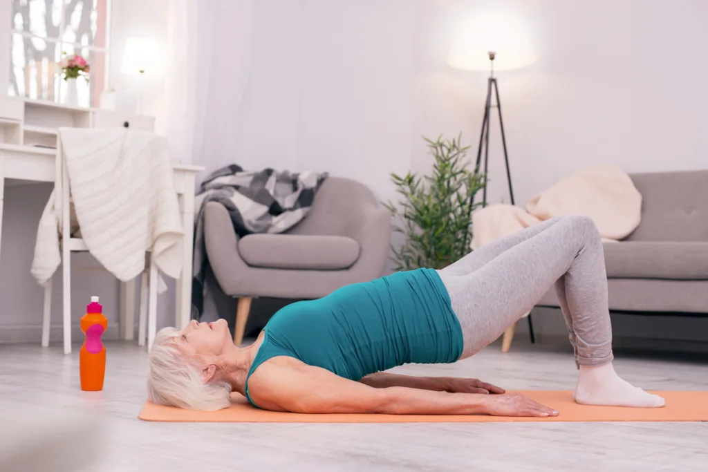 Sporty senior woman doing pelvic lift exercise