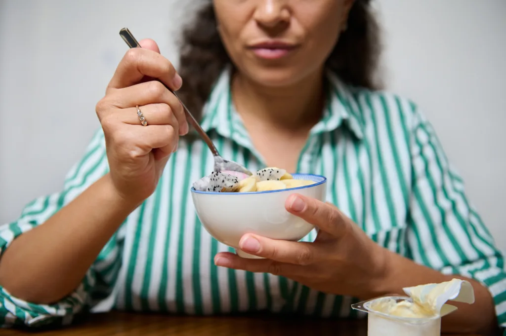 Woman enjoying a healthy fruit dessert at home