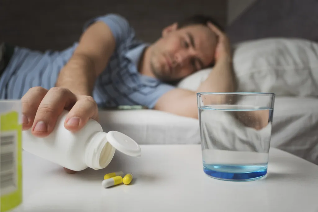 young man take medicine. self-medication. guy is being treated home with pills. Headache